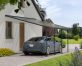 A blue Tesla is covered by a Grey Faria 13 ft. x 20 ft. lean-to carport