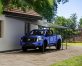 A blue truck is covered by a Grey Faria 13 ft. x 26 ft. lean-to carport