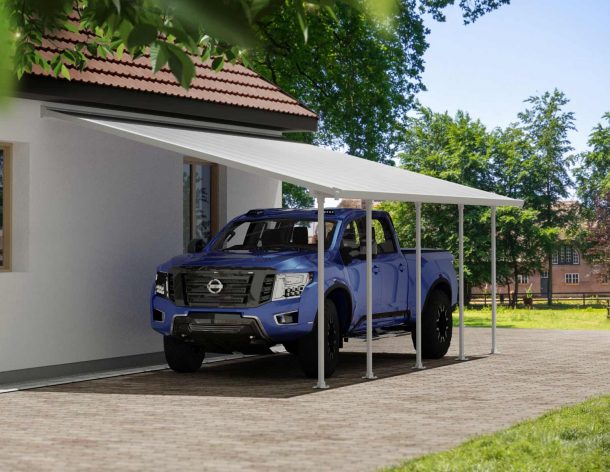 A blue truck is covered by a White Faria 13 ft. x 26 ft. lean-to carport