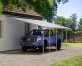 A blue truck is covered by a White Faria 13 ft. x 26 ft. lean-to carport