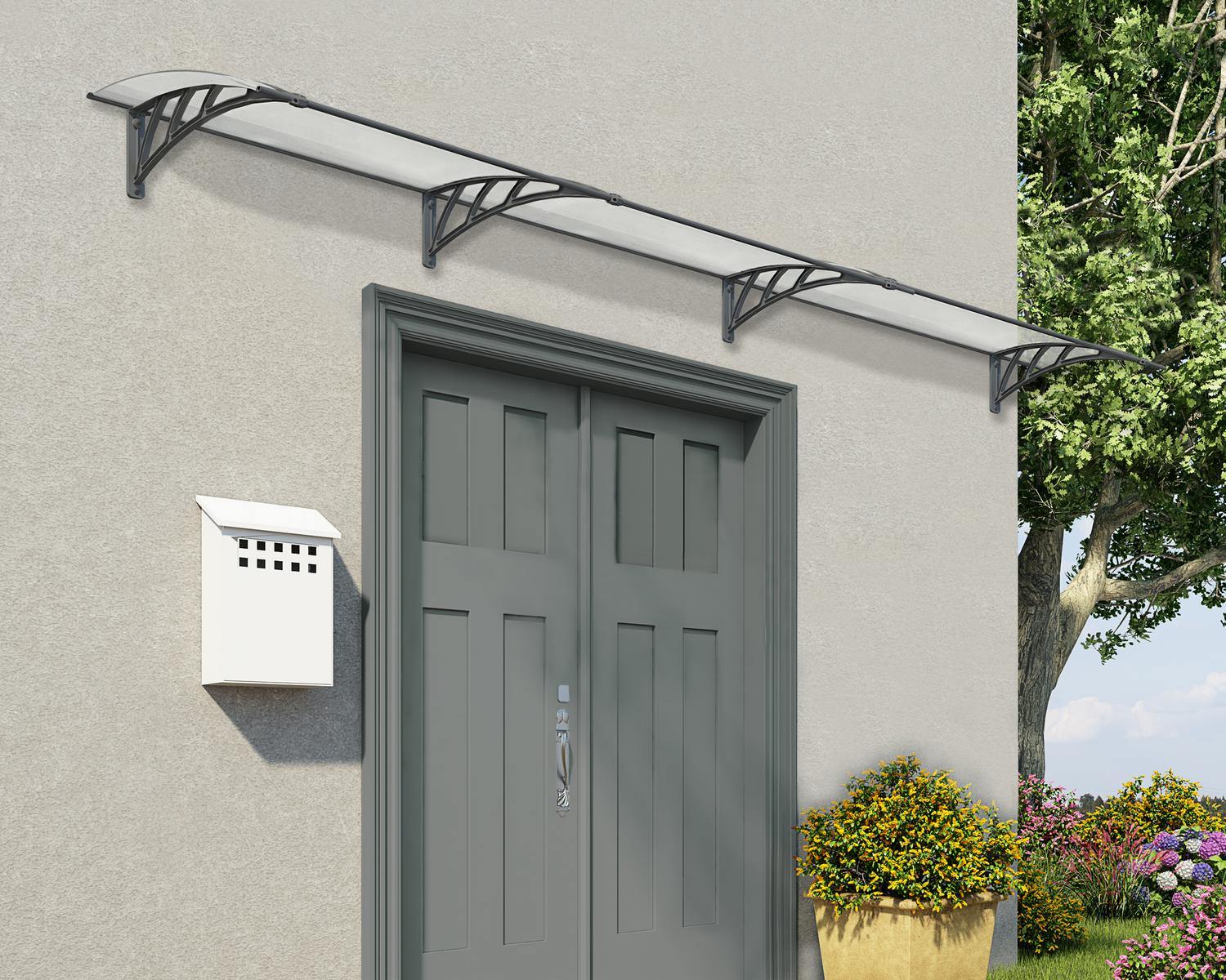 Grey twinwall Neo 3ft x 13.5ft door awning with a curved design, mounted above a window on a beige wall, featuring a vintage lantern