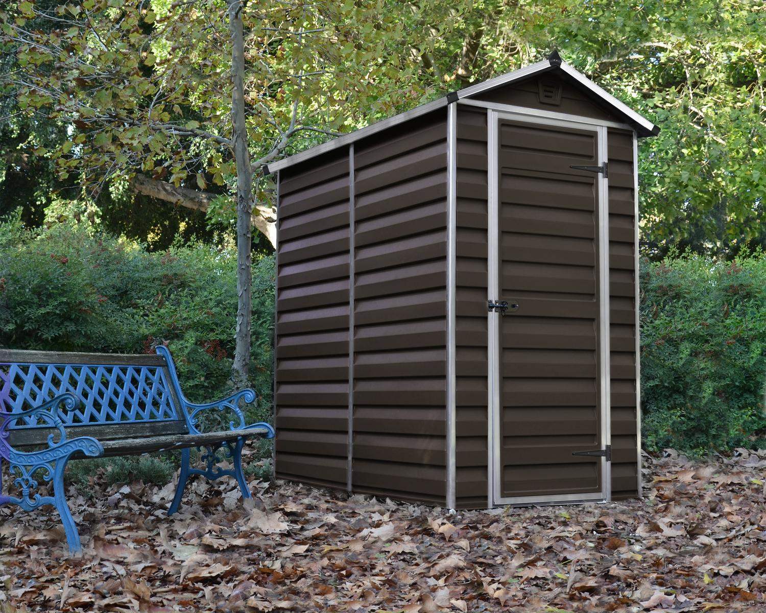 Brown Skylight storage shed, 4 ft x 6 ft, with modern design and white trim, on a concrete base beside a house