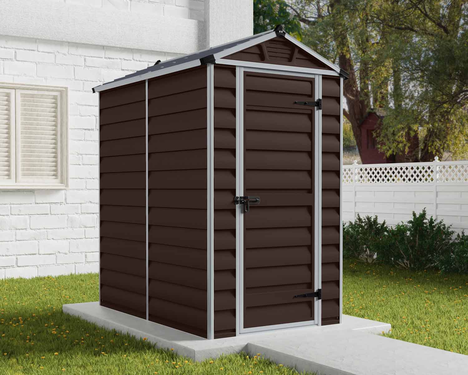 Brown Skylight storage shed, 4 ft x 6 ft, with modern design and white trim, on a concrete base beside a house