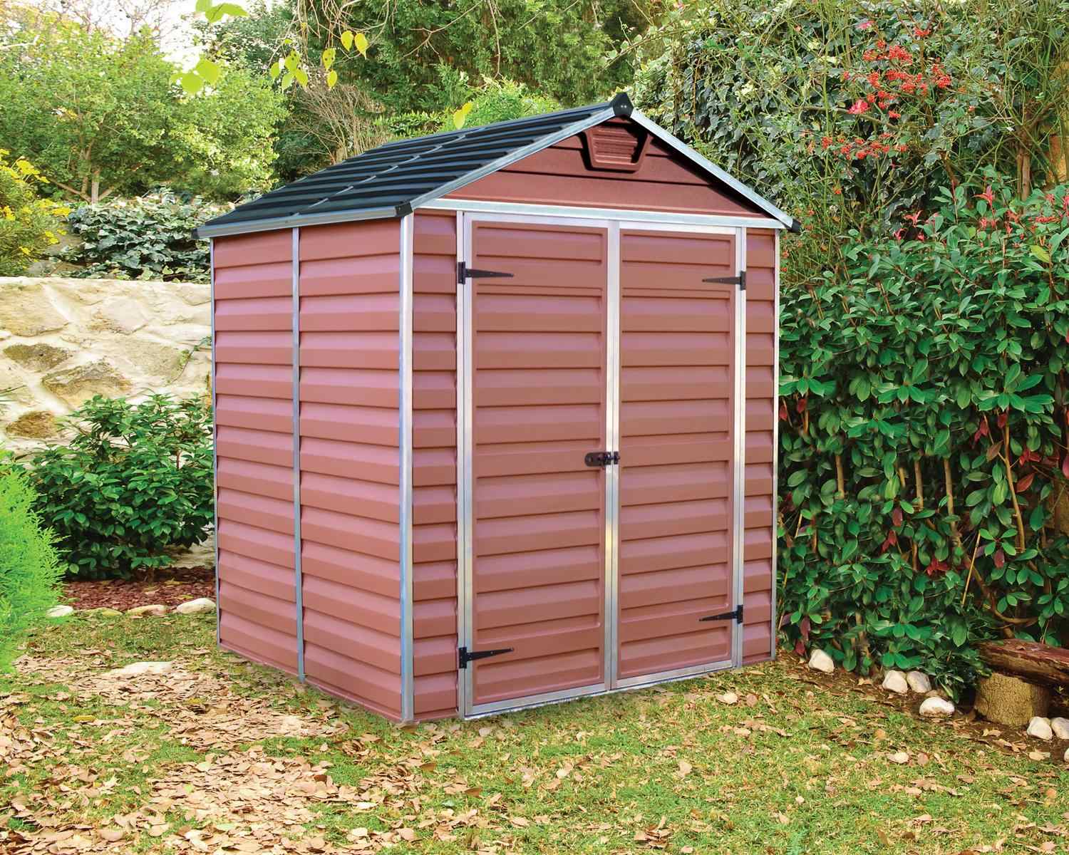 Amber SkyLight plastic storage shed, 6 ft x 5 ft, with a modern slanted roof design, positioned in a lush backyard