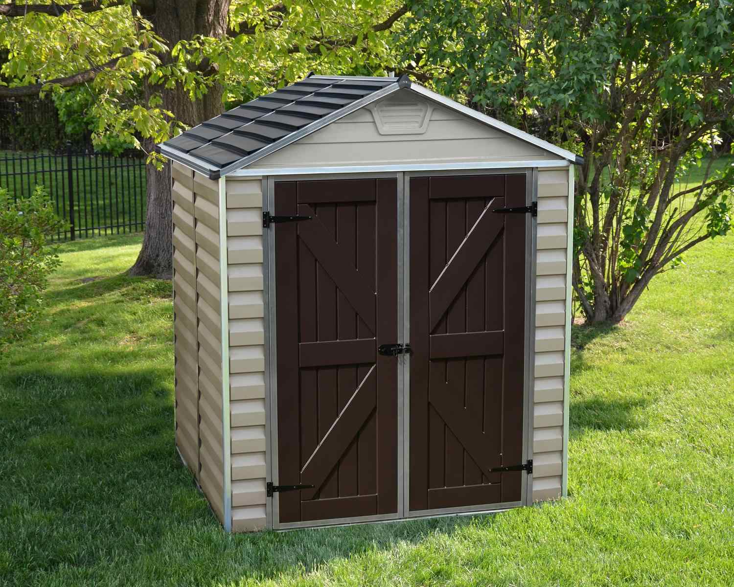 Stylish tan skylight plastic storage shed, 6 ft x 5 ft, set on a lush green lawn with trees