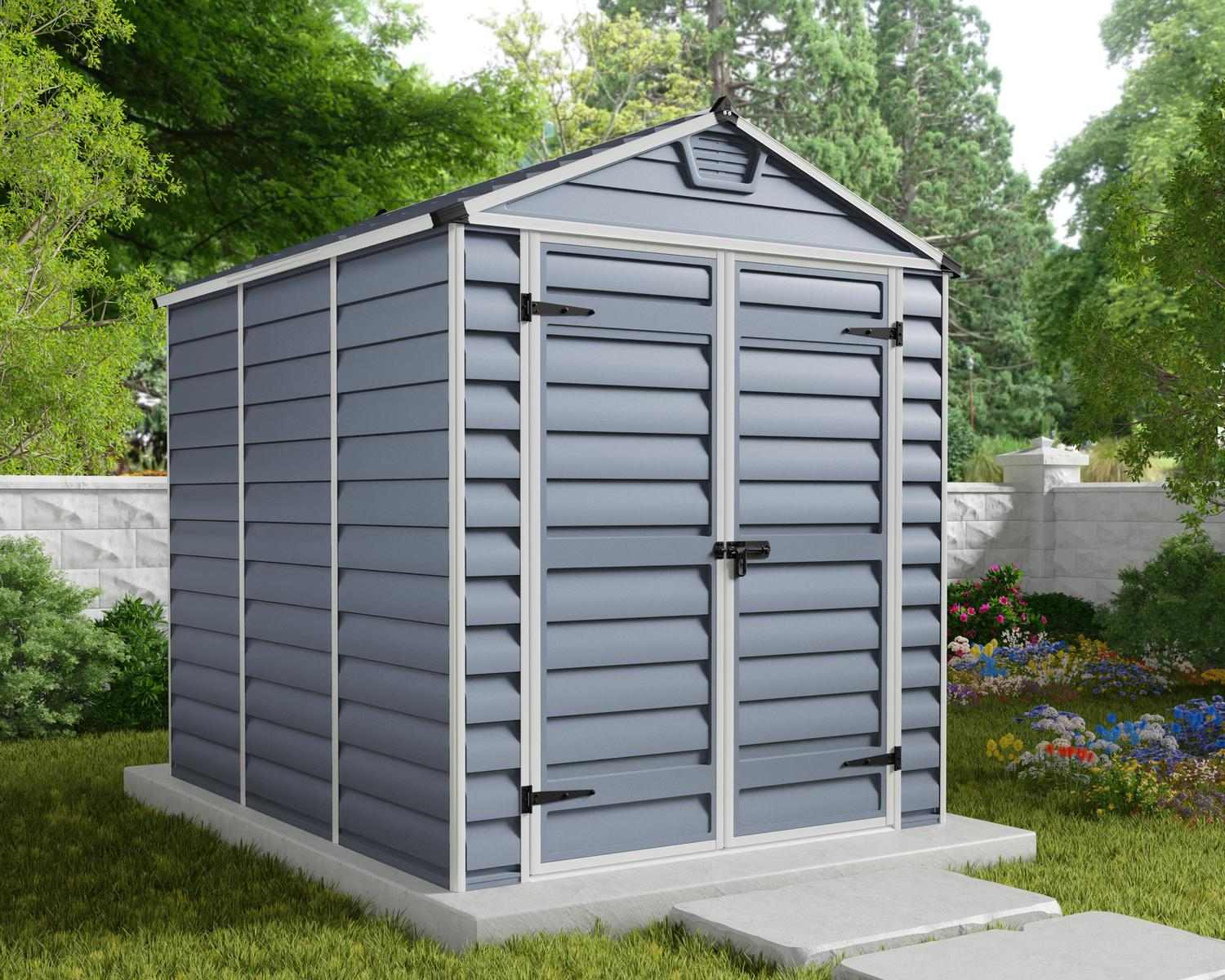 Dark grey skylight plastic storage shed, 6 ft x 8 ft, displayed in a lush outdoor setting surrounded by grass and plants