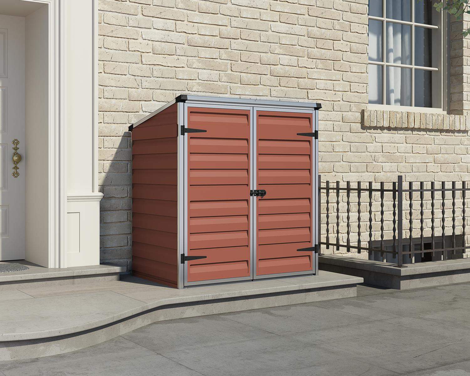 Voyager Plastic Storage Shed 2ft x 4ft in Amber, with a spacious interior against a brick wall near house entrance iron railing