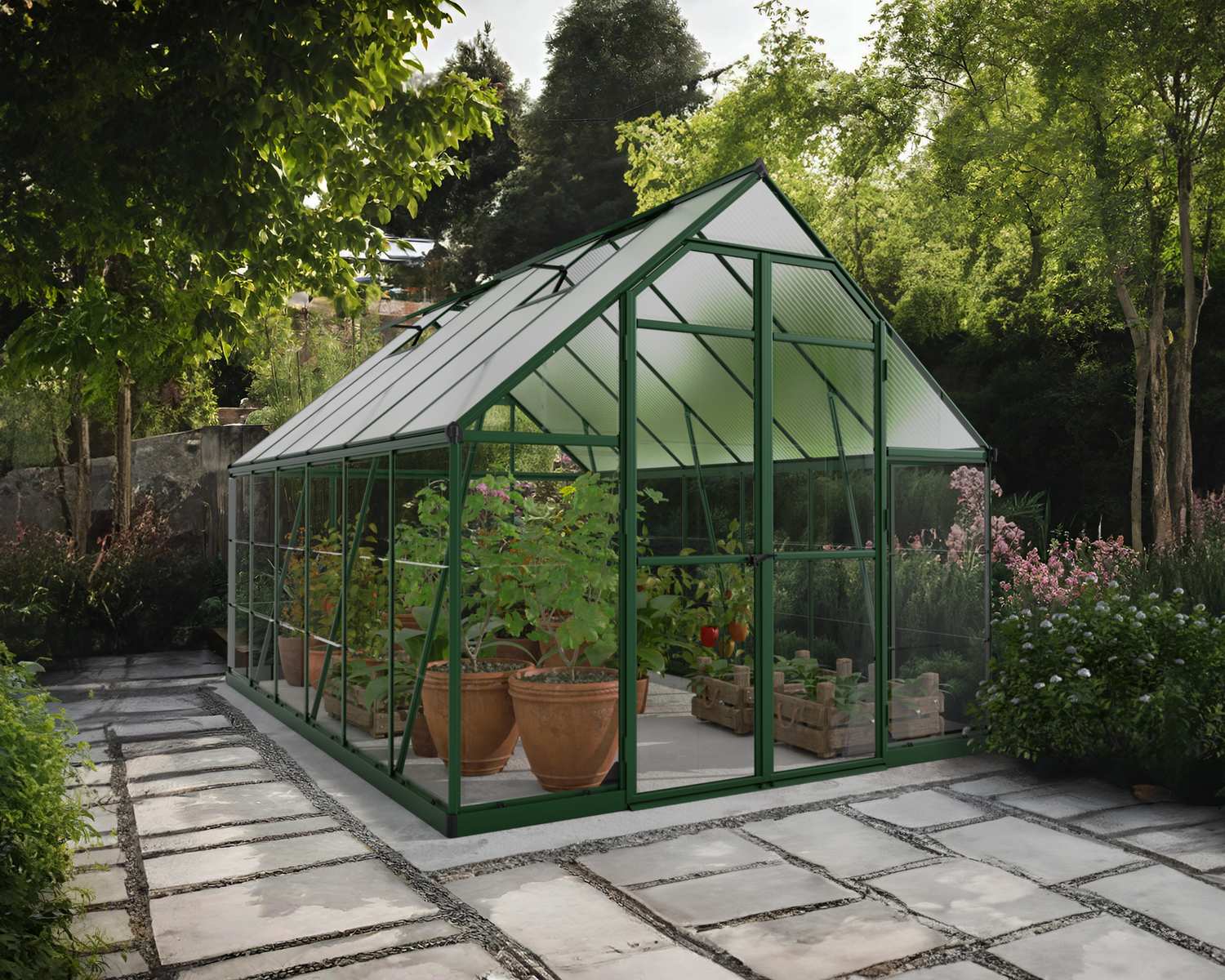 8ft x 12ft green Balance greenhouse with polycarbonate panels and aluminium frame, on a stone path surrounded by greenery