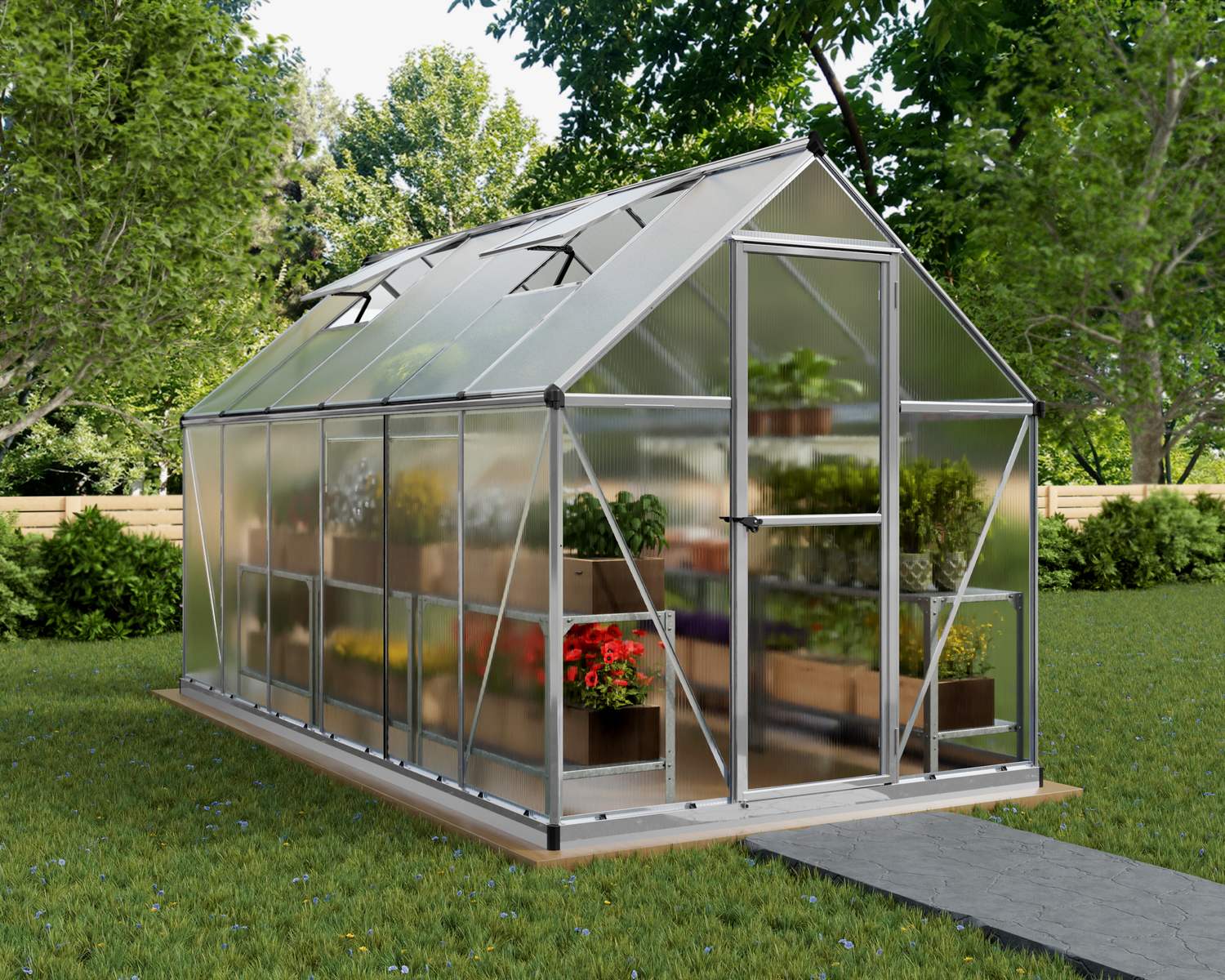 6ft x 12ft silver Mythos greenhouse with an aluminum frame and clear polycarbonate panels, set in a garden surrounded by greenery