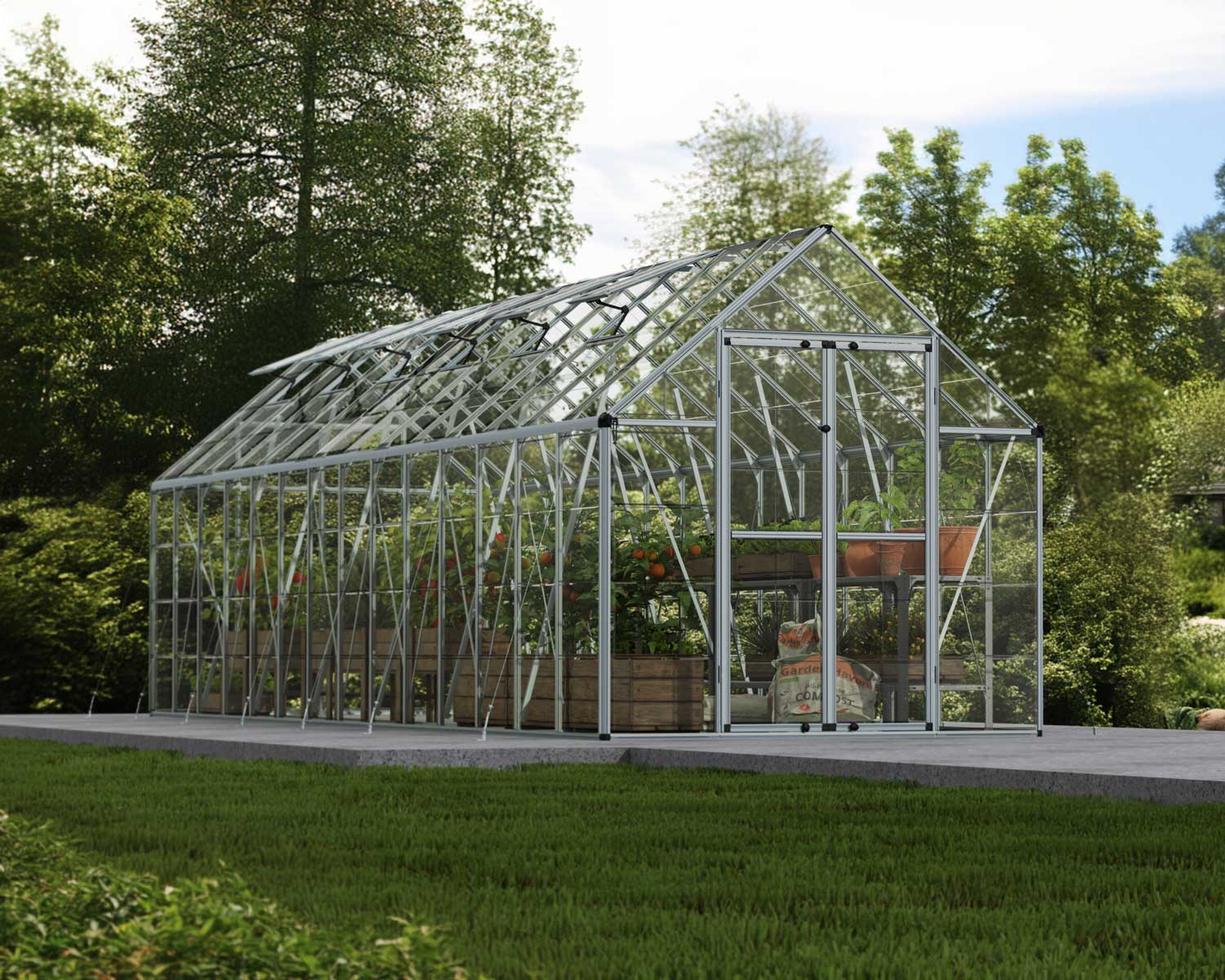 Silver SnapGrow 8ft x 28ft greenhouse with an aluminum frame and clear polycarbonate panels, filled with plants, set against a lush garden