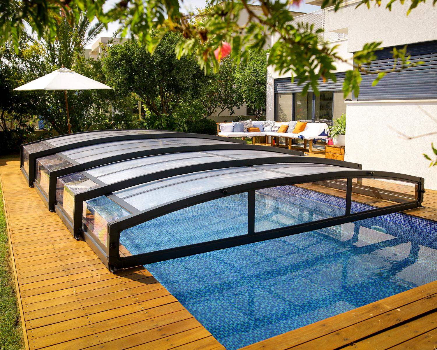 A pool enclosure covers a swimming pool at home