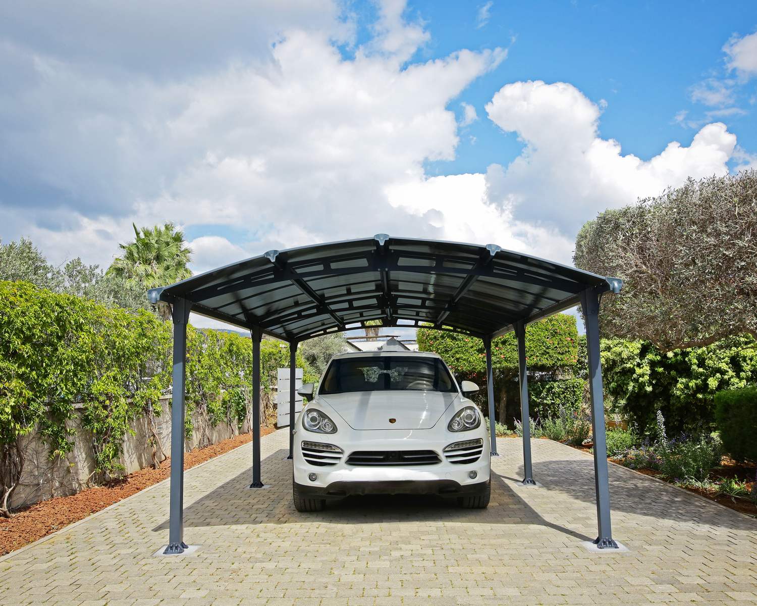 White car under a gray 12ft x 21ft Arcadia aluminum carport with a curved roof