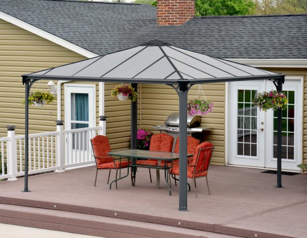 Palermo 12&#039;x12&#039; grey aluminum gazebo with polycarbonate roof panels on a deck patio with garden dining furniture