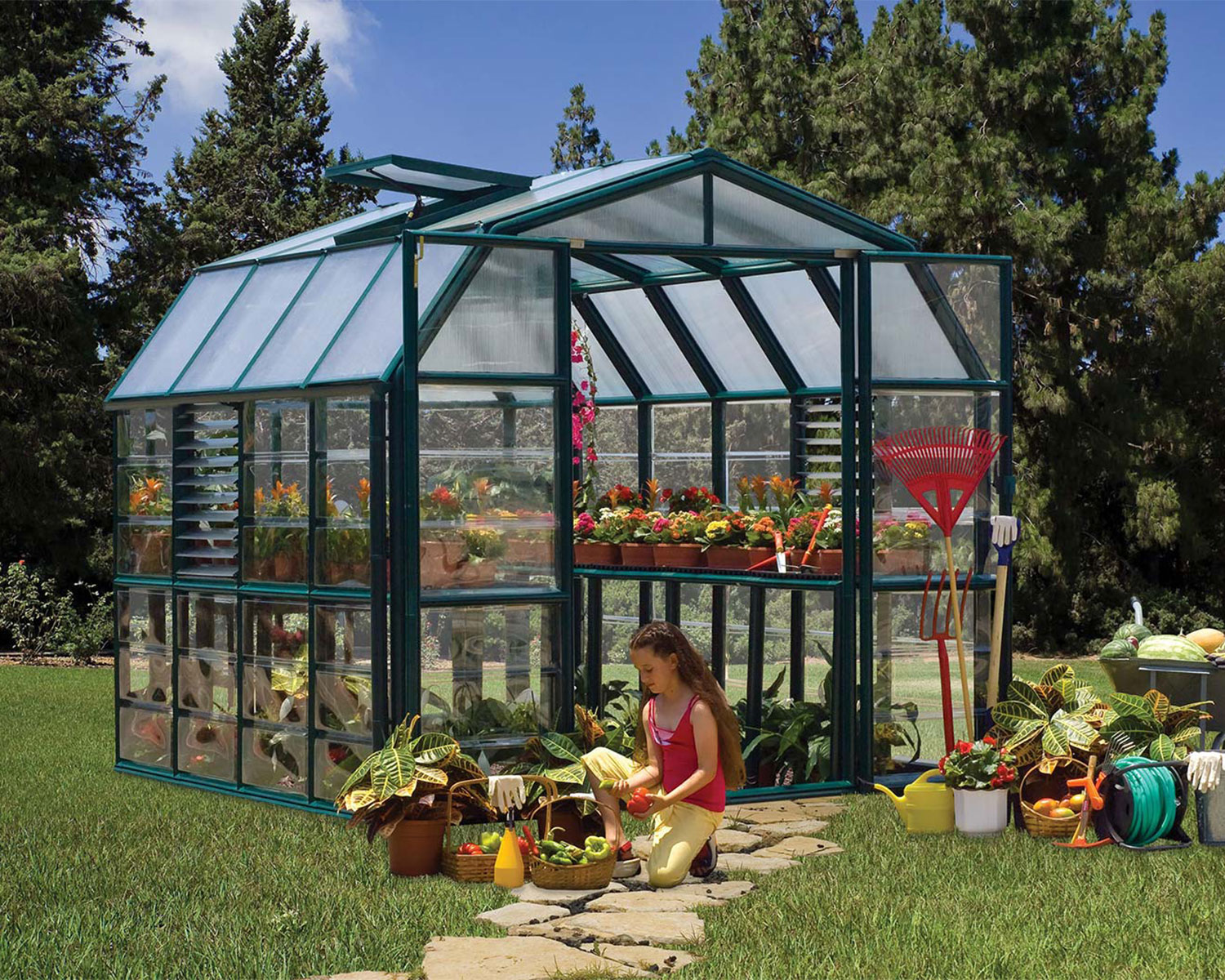 Snap & Grow 6 ft. x 12 ft. Greenhouse Silver Structure & Clear Panels and a girl in front with a basket of vegetables