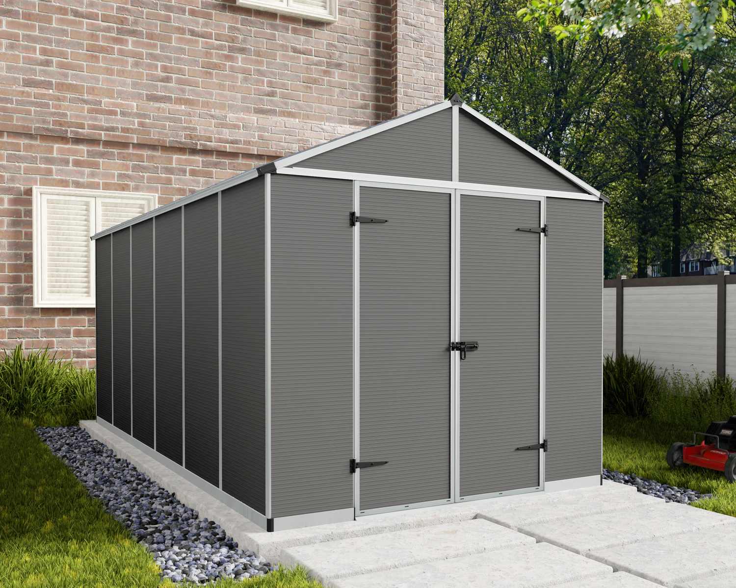 Dark grey Rubicon plastic storage shed, 8 ft x 15 ft, with double doors, on a concrete base beside a brick house