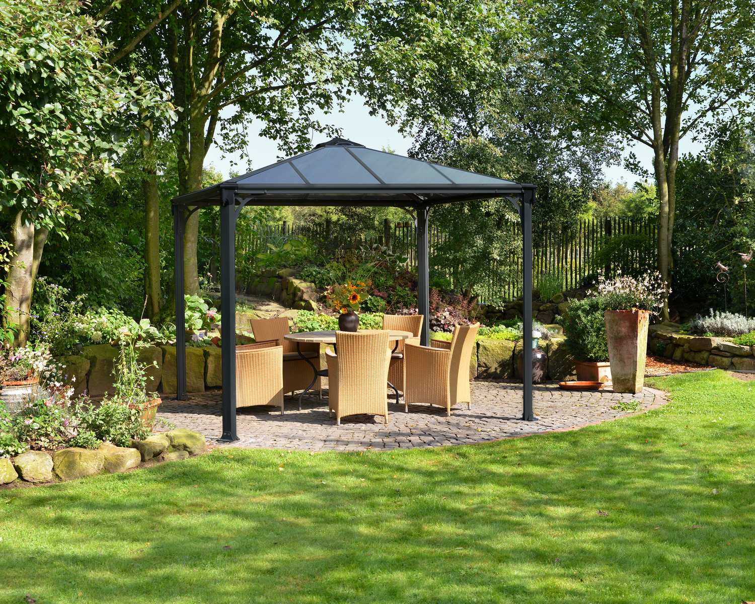 Palermo 10ft x 10ft grey aluminum gazebo with a sleek design and sturdy frame, featuring a dining set on a deck in a garden