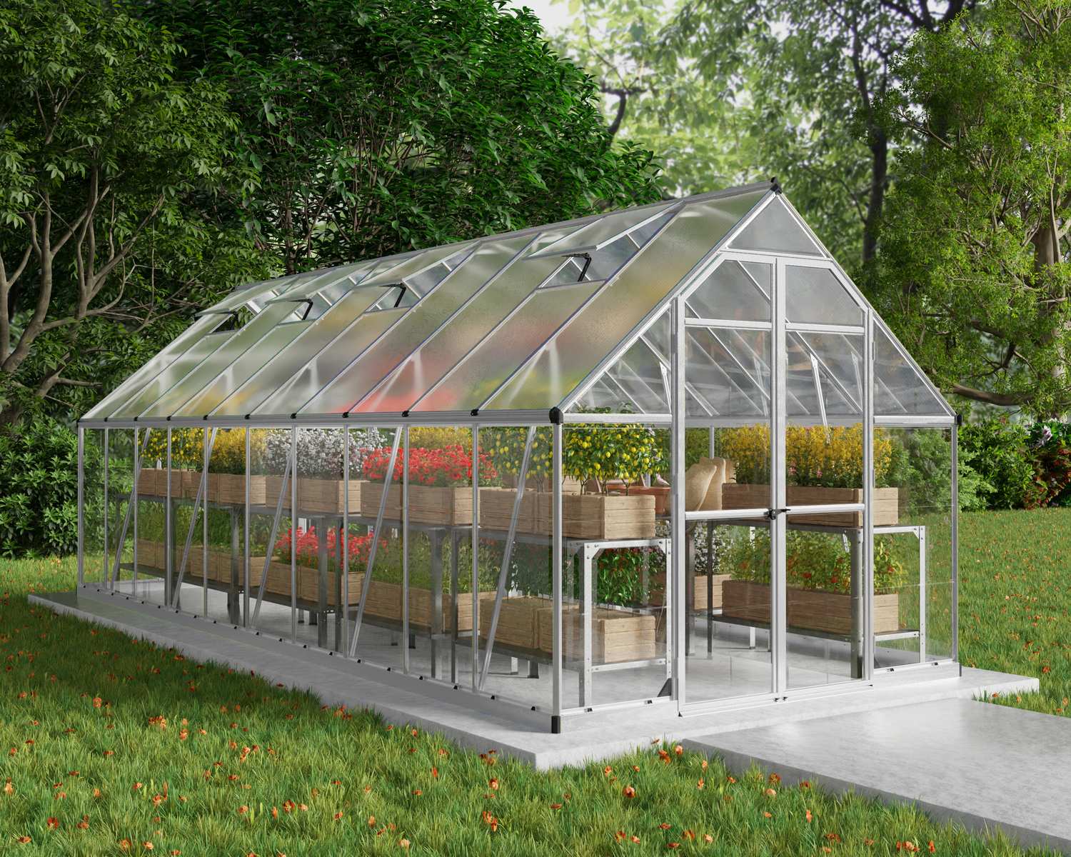 Balance 8ft x 20ft silver greenhouse with clear polycarbonate panels and aluminium frame, set in a garden with plants surrounding it