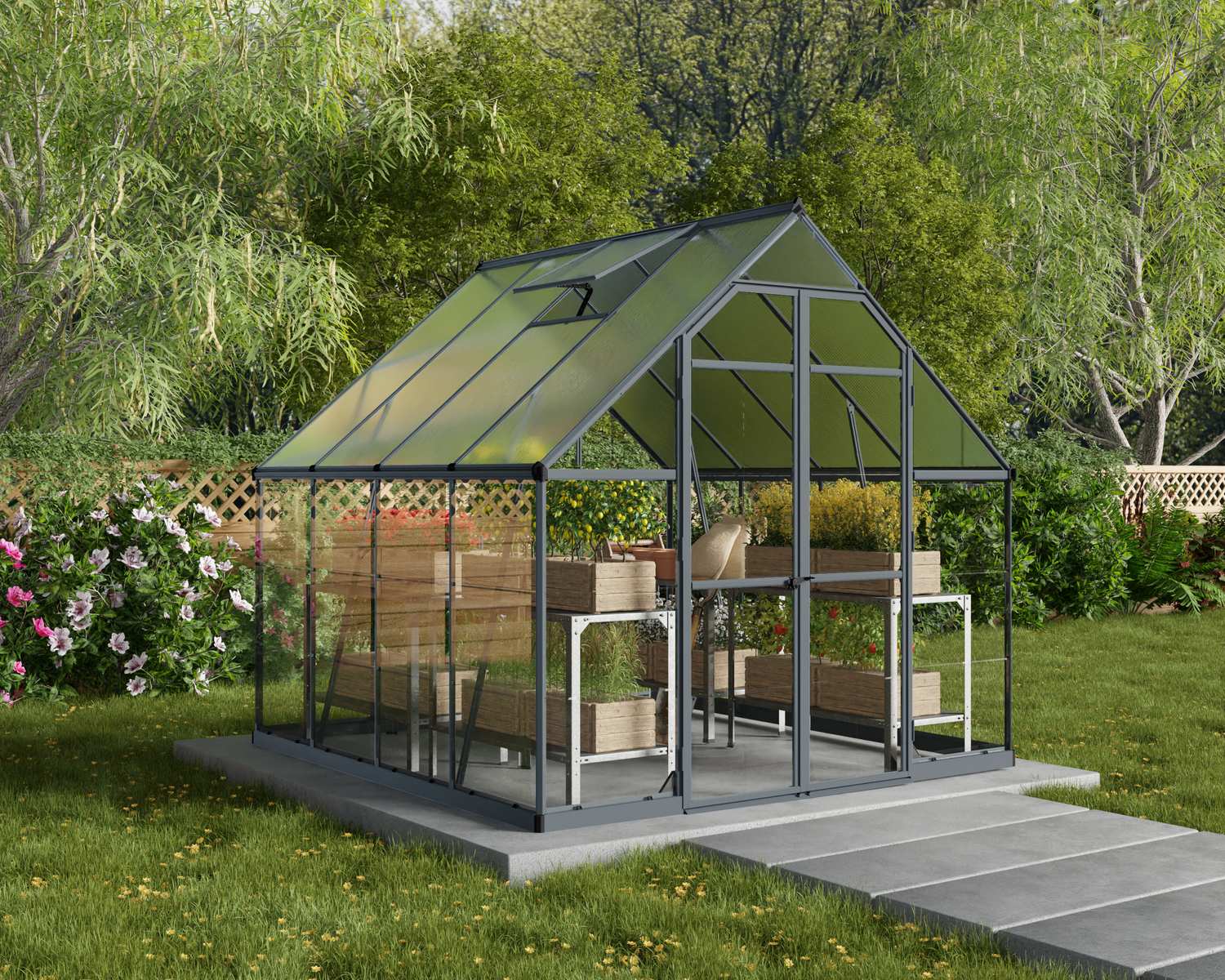 Balance 8ft x 8ft grey greenhouse with polycarbonate panels and aluminium frame, on a patio surrounded by greenery and flowers