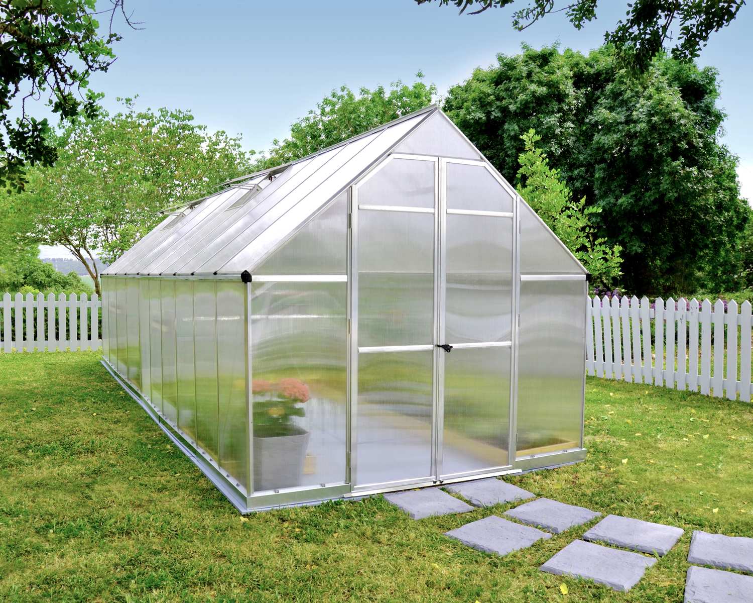 Essence 8x20 Silver greenhouse with polycarbonate panels, set in a spacious garden for optimal plant growth