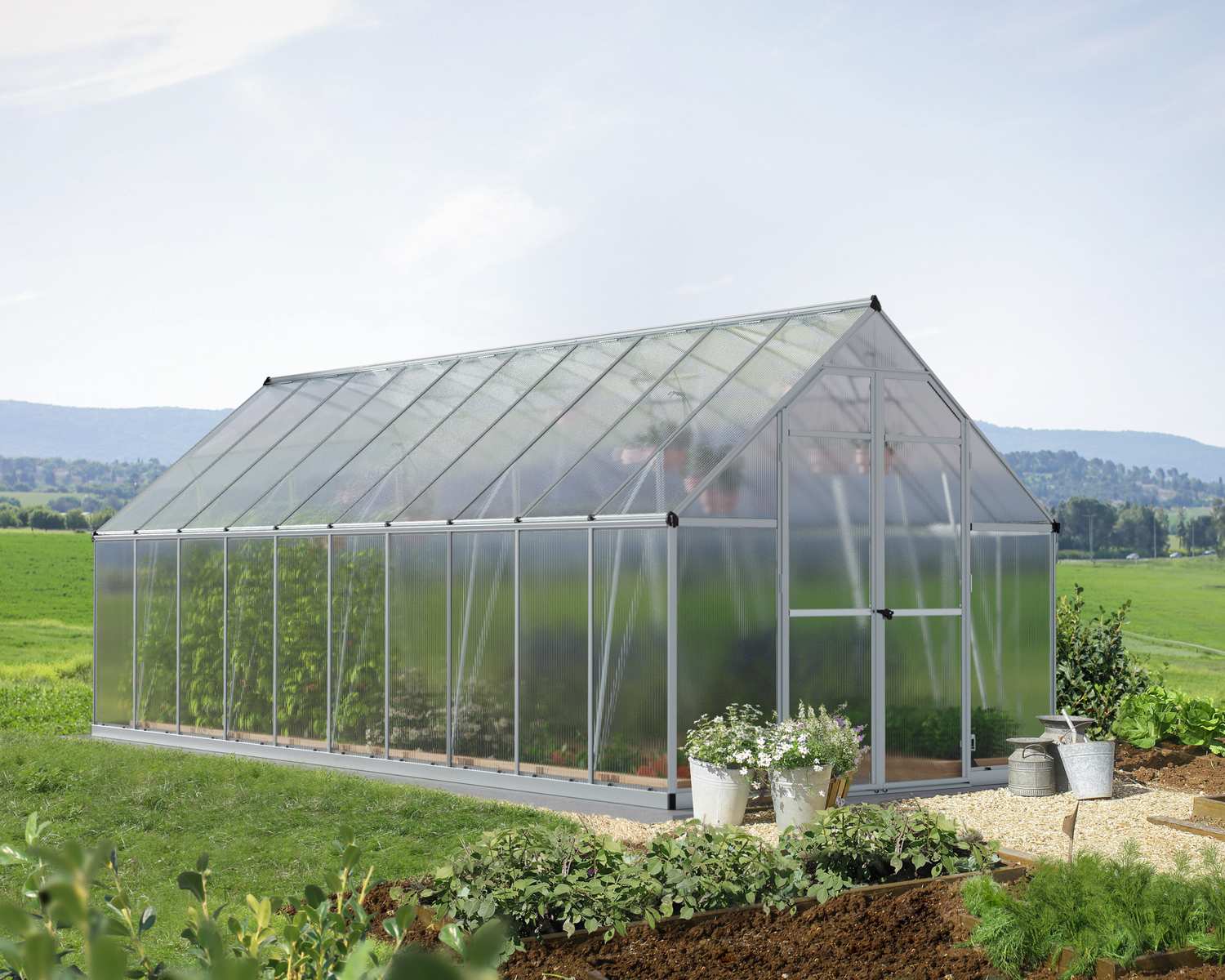 Essence 8x20 Silver greenhouse with polycarbonate panels, set in a spacious garden for optimal plant growth