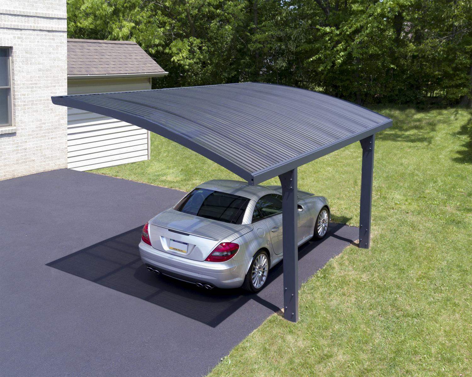 10ft x 16ft Arizona Wave carport with a grey aluminum frame and polycarbonate roof panels, sheltering a sports car next to lush green shrubbery