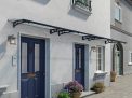 Grey Altair 5m x 0.9m door canopy with clear polycarbonate panels, offering stylish protection for entryways with a contemporary design