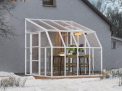 2.5m x 2.5m white Lean to Conservatory sunroom with clear polycarbonate panels, featuring a spacious design, with a dining set inside during snowfall