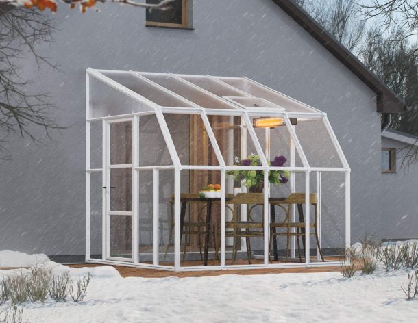 2.5m x 2.5m white Lean to Conservatory sunroom with clear polycarbonate panels, featuring a spacious design, with a dining set inside during snowfall