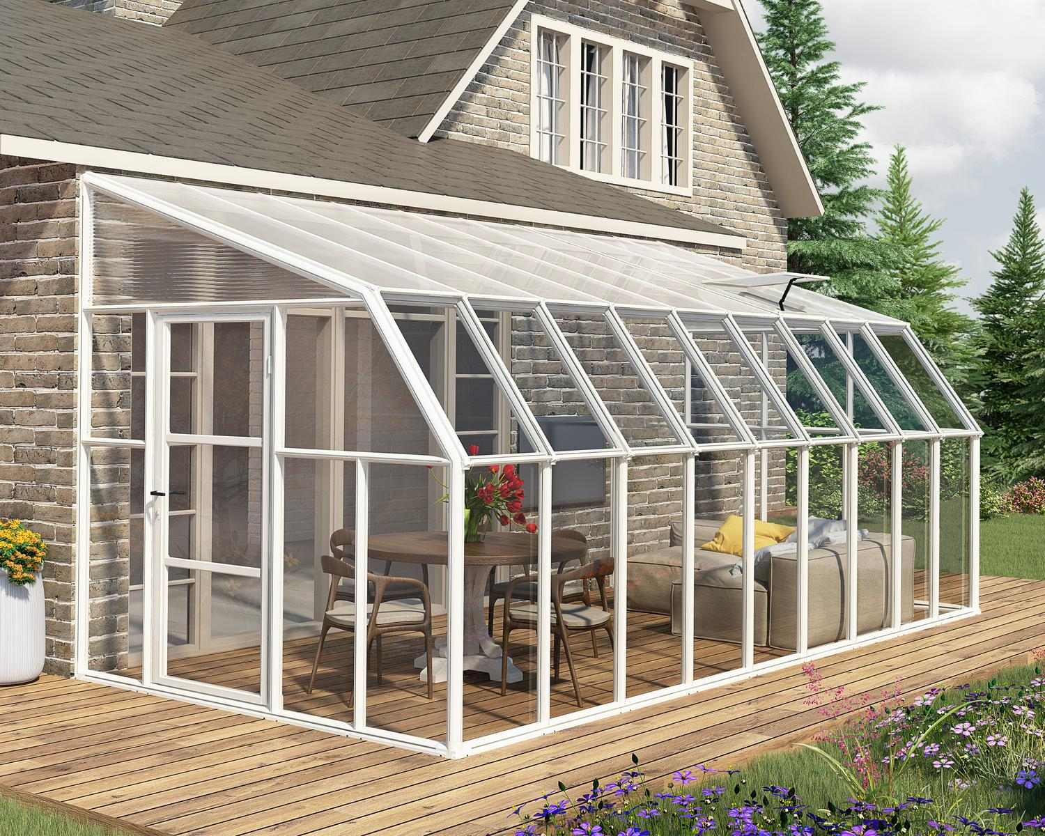 2.5m x 5.7m white Lean to Conservatory sunroom with clear polycarbonate panels, attached to a brick house and set on a wooden deck with greenery