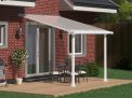 White Olympia patio cover, 3m x 3m, with a sturdy aluminum frame and clear polycarbonate panels, providing weather protection and shade