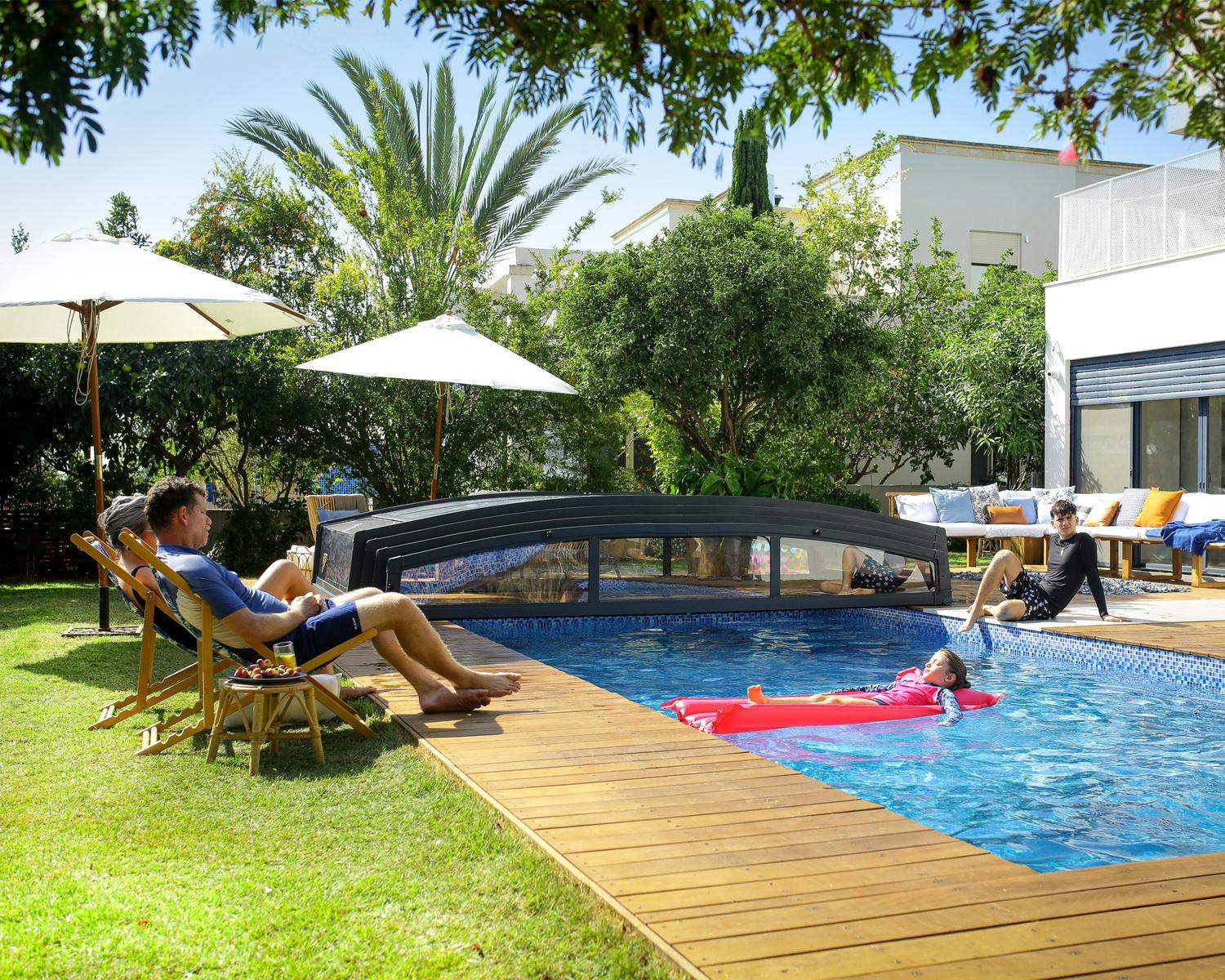 A pool enclosure covers a swimming pool at home