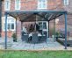 Outdoor Aluminium gazebo with a polycarbonate roof panles on a garden patio