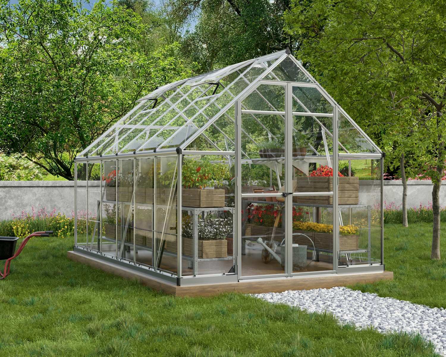 8ft x 12ft silver Octave greenhouse with an aluminum frame and clear polycarbonate panels, filled with plants, set in a lush garden with trees