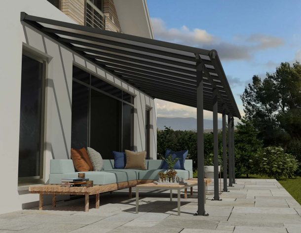 Grey Olympia patio cover, 3m x 8.6m, with an aluminum frame and clear polycarbonate panels, offering shade and protection for outdoor spaces