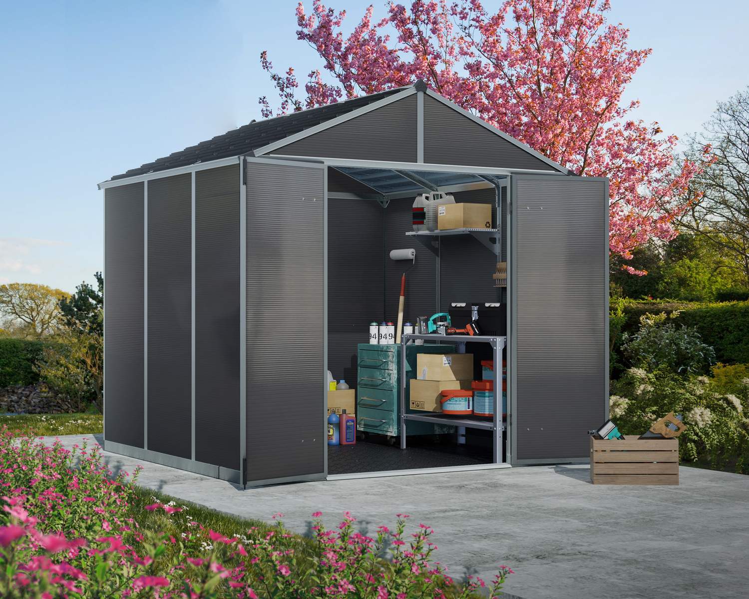 8ft x 8ft grey Rubicon garden shed with a sturdy aluminum frame and multiwall polycarbonate panels, set in a garden with pink blossom trees