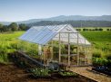 10ft x 28ft silver Balance greenhouse with an aluminum frame and clear polycarbonate panels, set in a garden