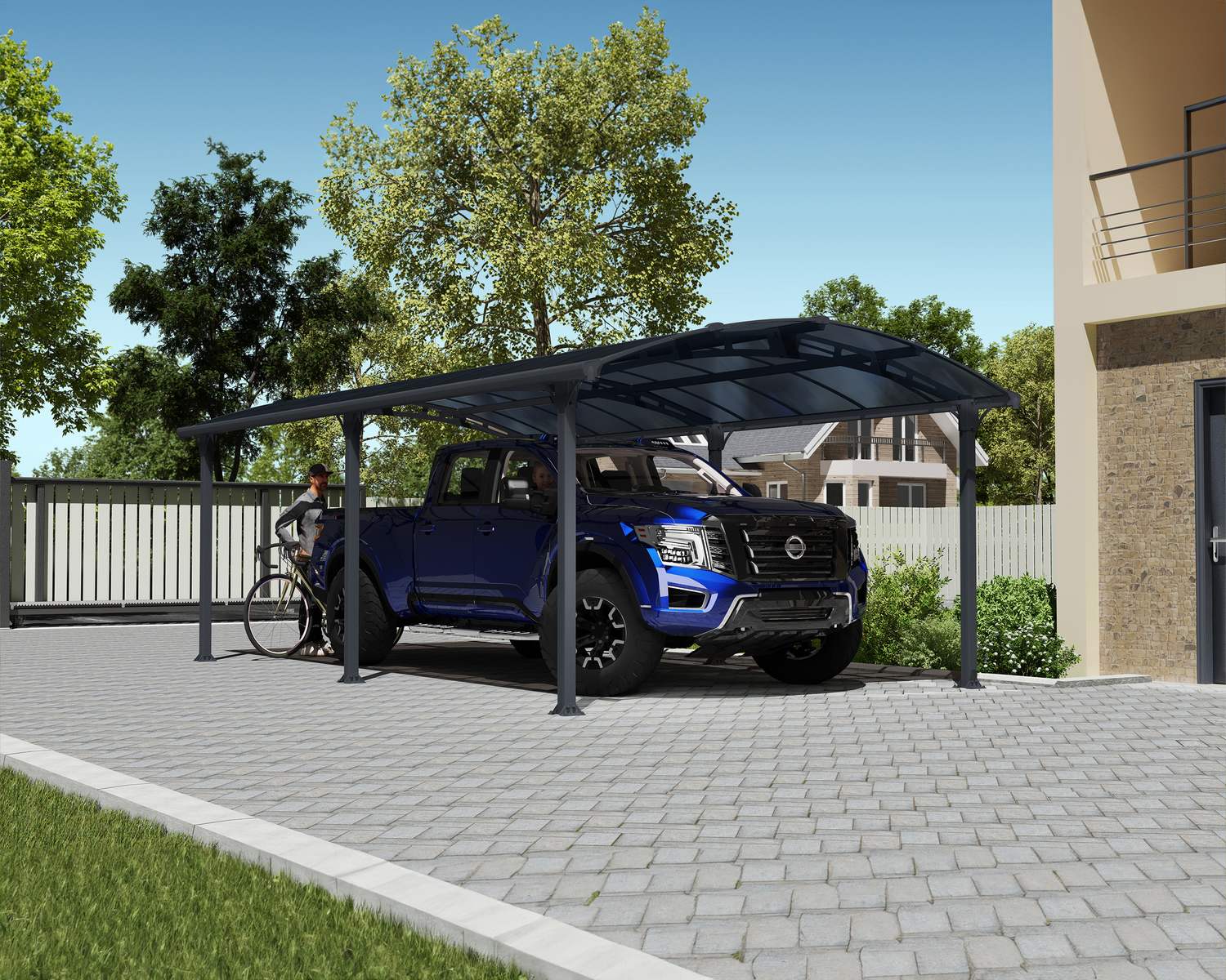 12ft x 21ft Arcadia carport with a grey aluminum frame and polycarbonate roof, offering shelter for a pickup truck next to a brick house