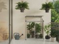 4ft x 2ft silver Lean-To Grow greenhouse with clear polycarbonate panels and an aluminum frame, attached to a wall, surrounded by snow
