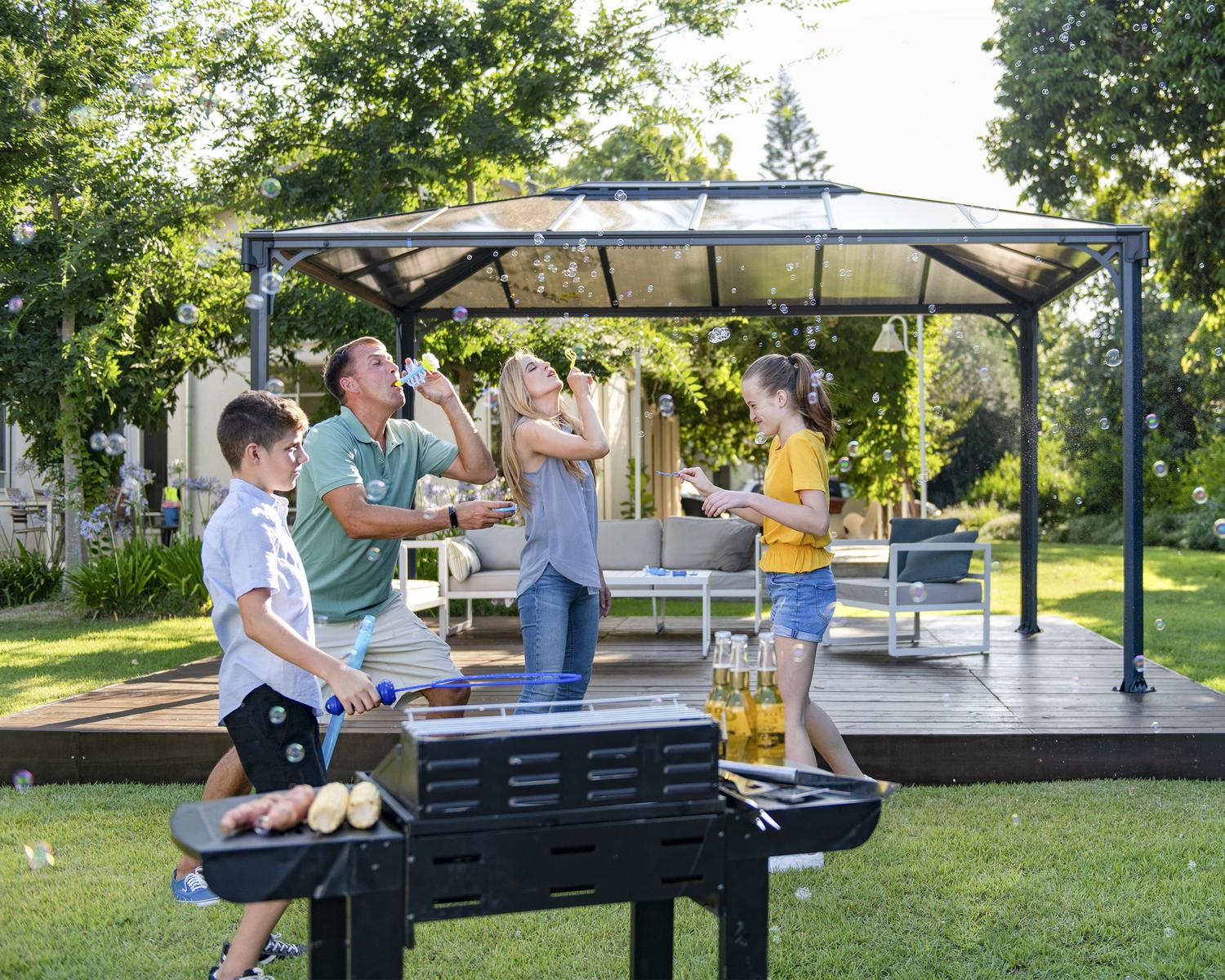Martinique 3m x 4.3m grey garden gazebo with an aluminum frame and polycarbonate roof panels, set in an outdoor environment