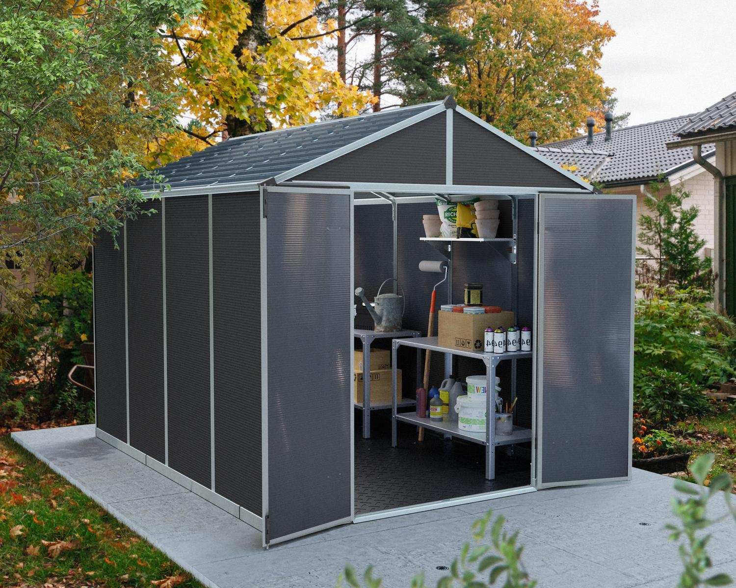 8ft x 10ft grey Rubicon garden shed with an aluminum frame and polycarbonate panels, featuring shelves and tools in an autumn garden