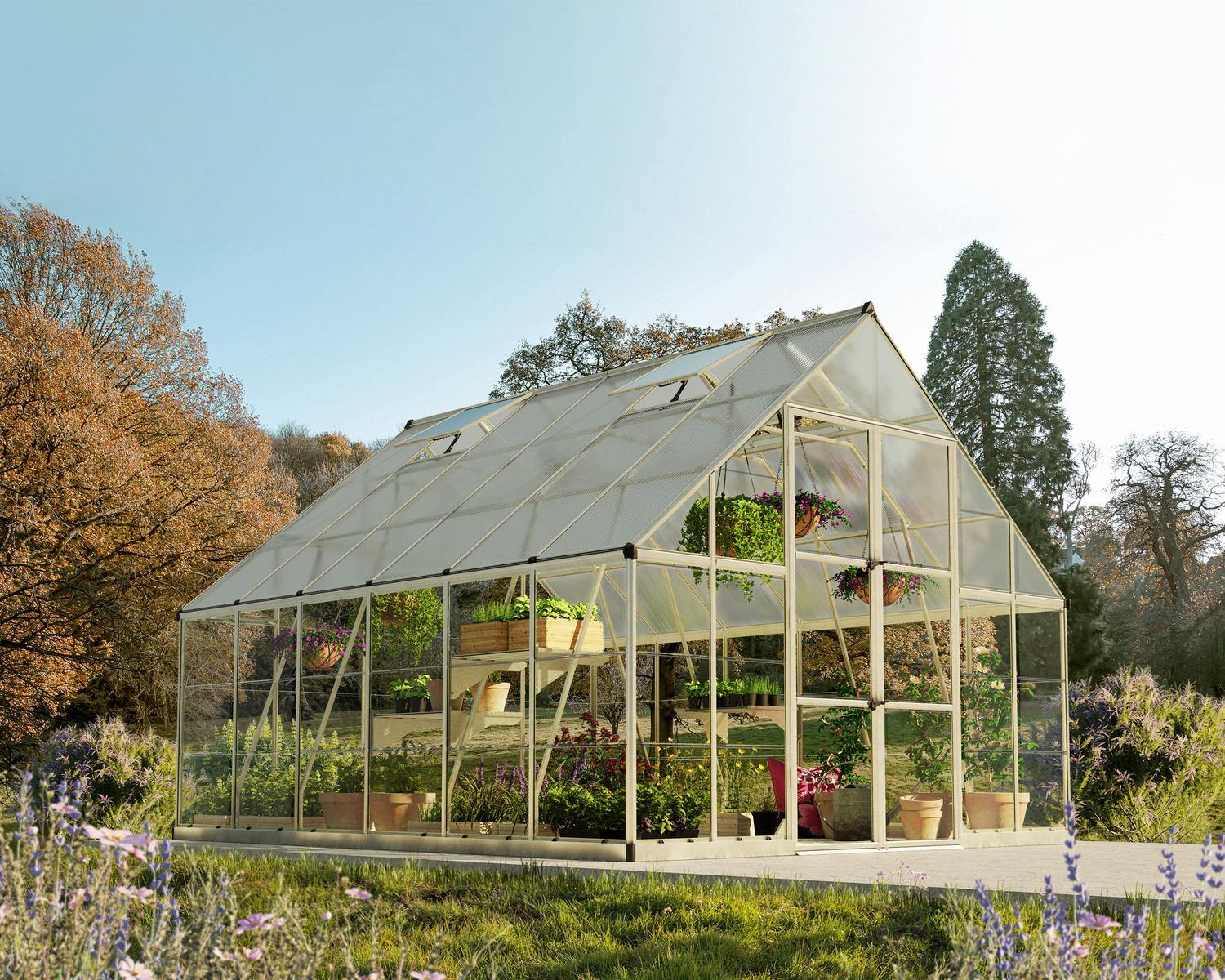 10ft x 12ft silver Balance greenhouse with an aluminum frame and clear polycarbonate panels, filled with vibrant plants and nestled in lush greenery