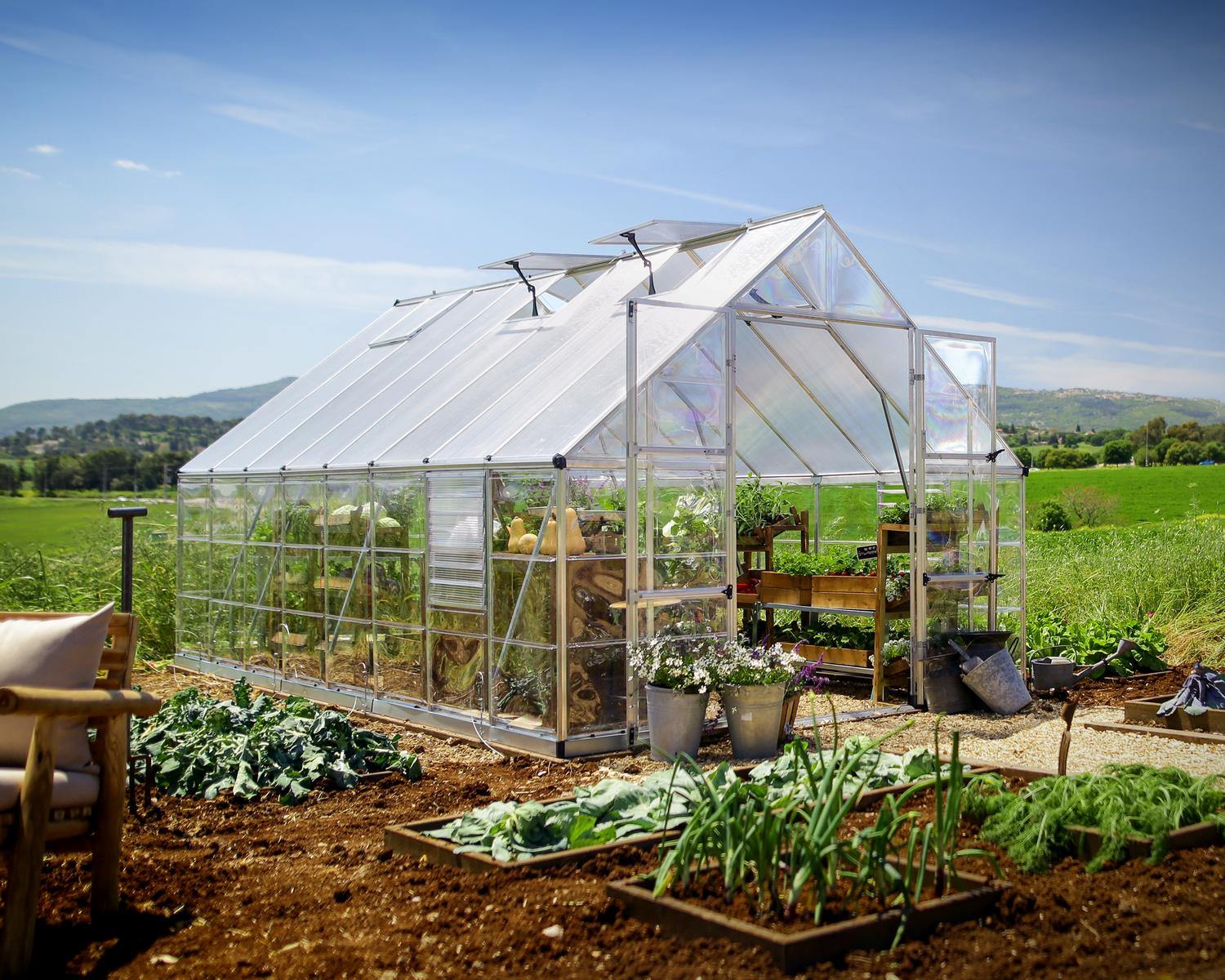 10ft x 16ft silver Balance greenhouse with an aluminum frame and clear polycarbonate panels, set in a garden with plants inside