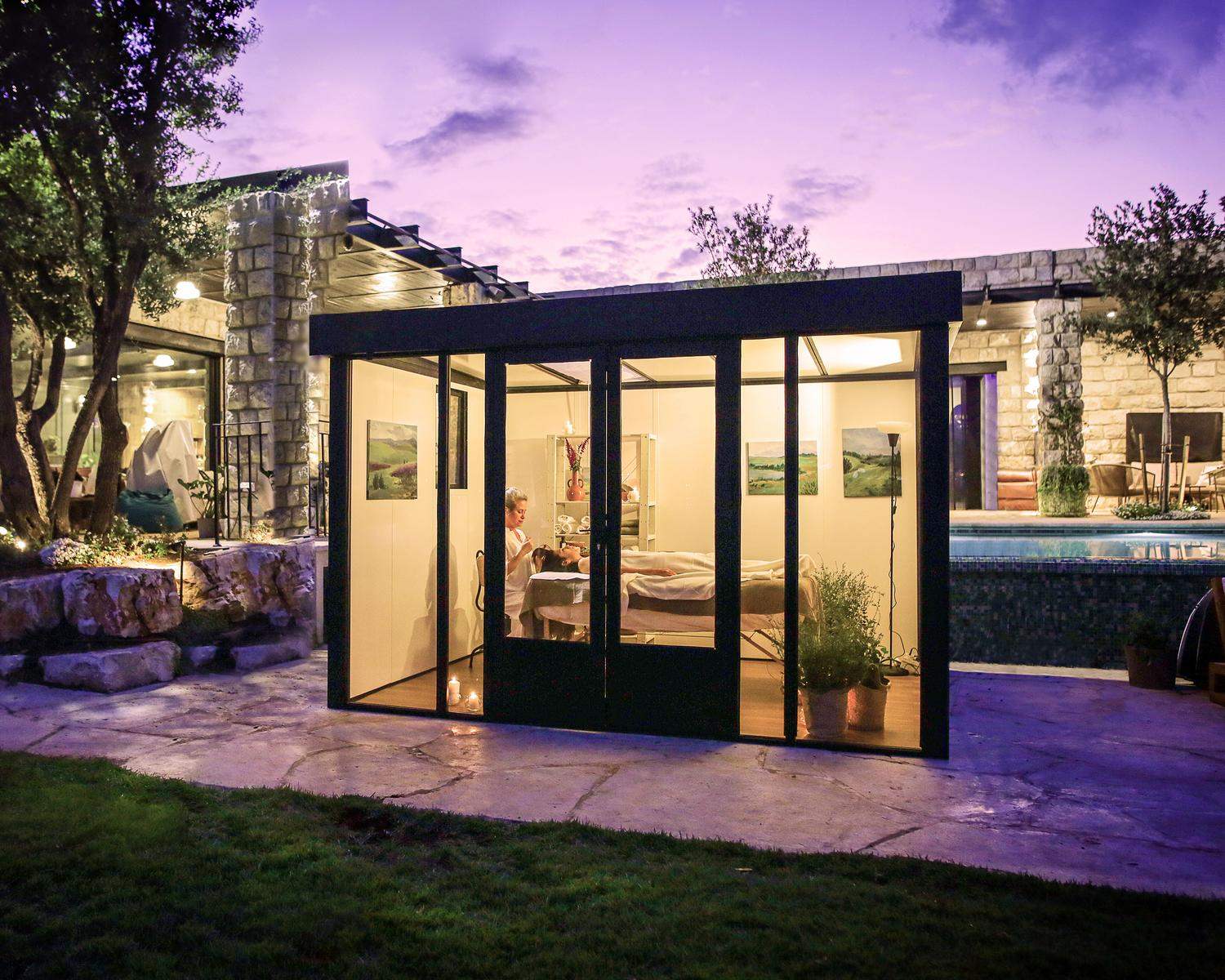 Copenhagen 3m x 3.5m black lean-to conservatory with an aluminum frame and clear polycarbonate panels, set in a sunset garden