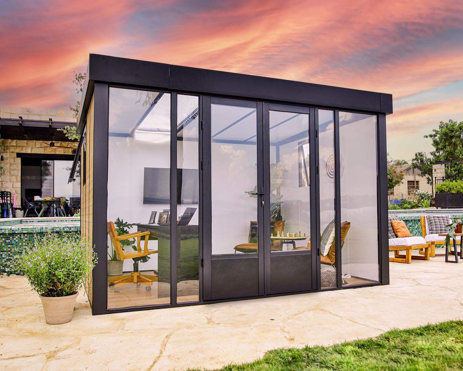 Copenhagen 3m x 3.5m black lean-to conservatory with an aluminum frame and clear polycarbonate panels, set in a sunset garden