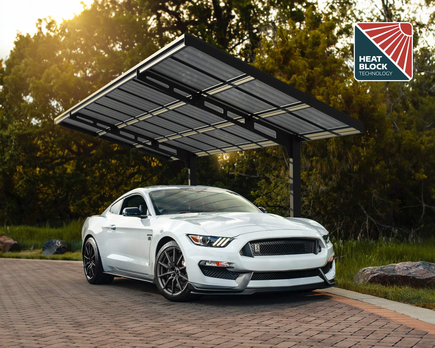 10ft x 20ft Sydney Wave carport with a black aluminum frame and polycarbonate roof, sheltering a white sports car in greenery