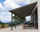 Grey Aluminium Patio Cover with Bronze-tinted twin-wall polycarbonate roof panels protect garden furniture 
